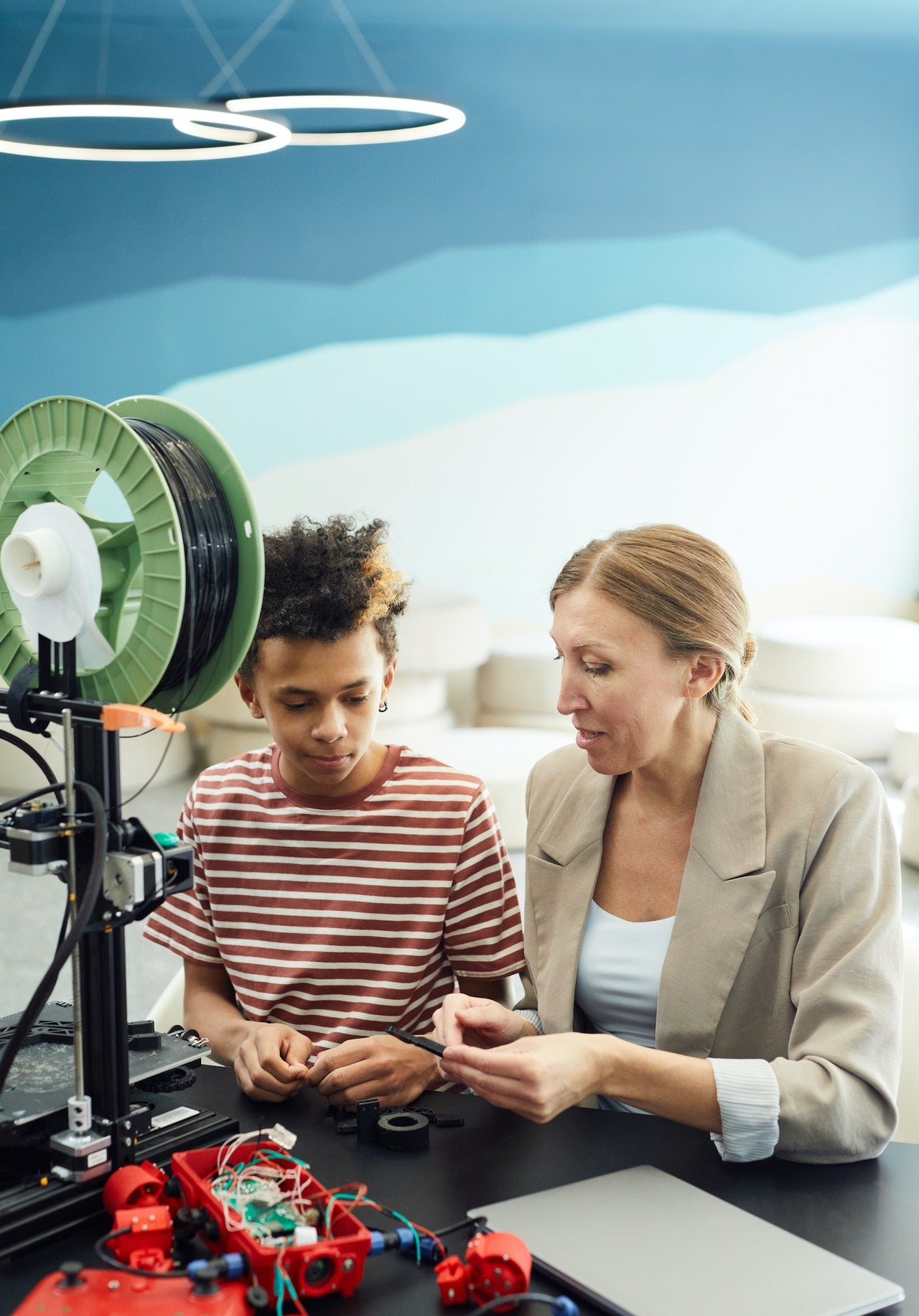 Teacher and student using a 3d printer