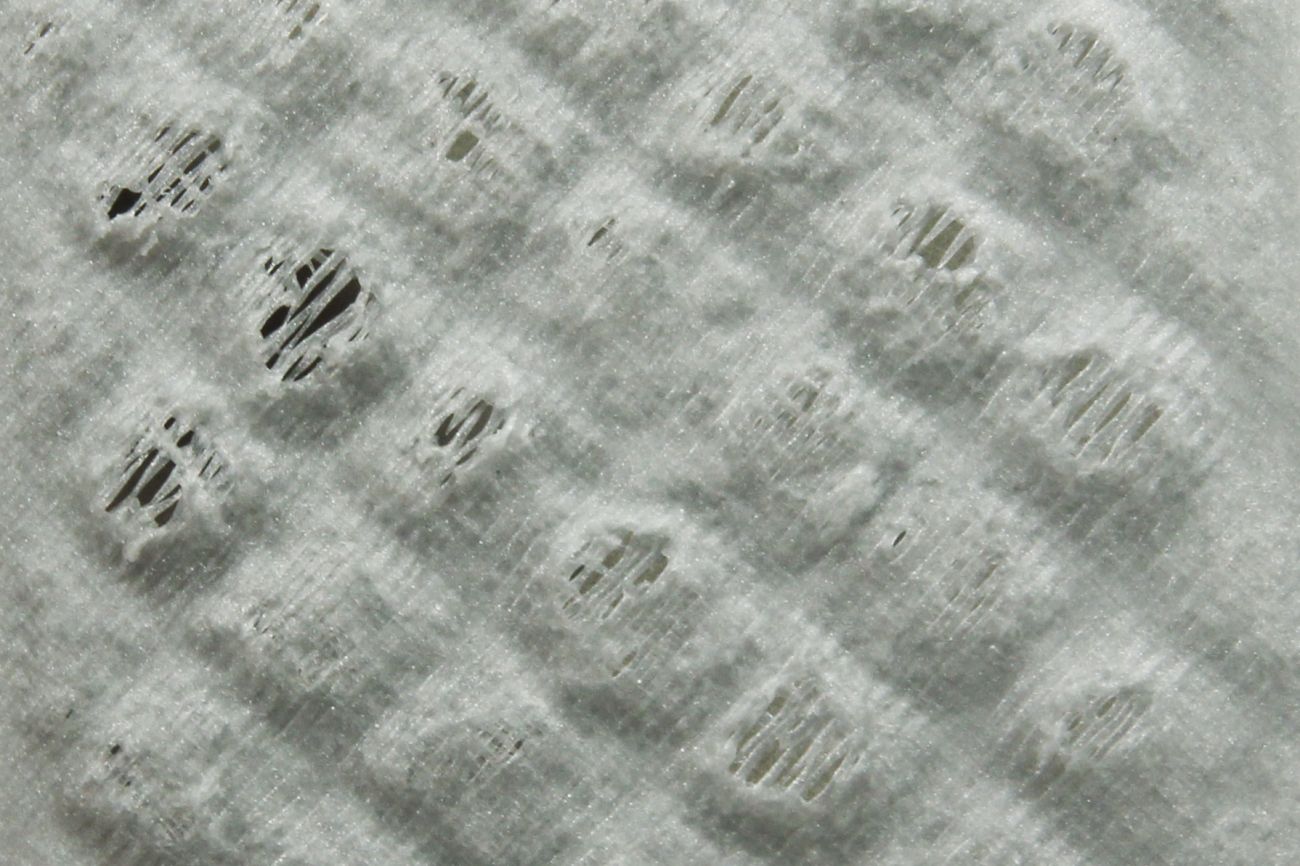 Does the top layer have pits and hollows (pillowing)?