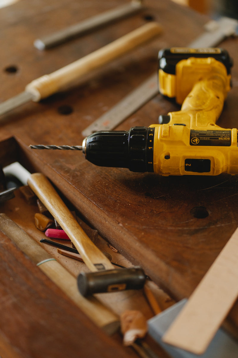 Electric drill and tools on bench
